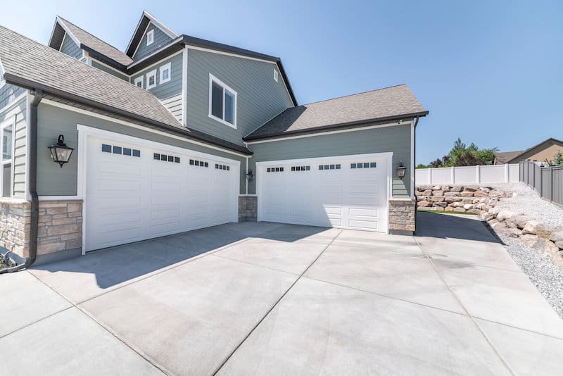 Residential home showing concrete driveway and garage doors — Precision Concrete Leveling Winnipeg since 2004